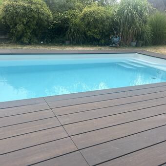 Pooldeck aus WPC-Dielen mit Blick auf den Pool und den Garten